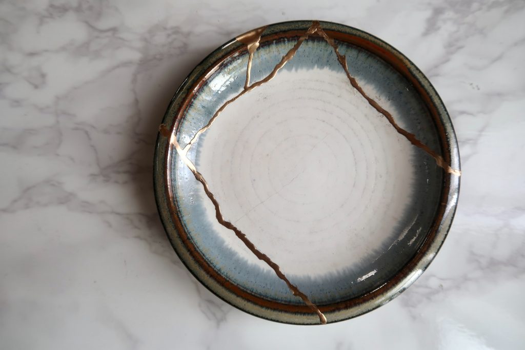 Muestra un plato reparado con oro a través de la técnica japonesa Kintsugi, que nos enseña, al igual que la psicoterapia psicoanalítica en Chamberí que las heridas, o las grietas se pueden transformar y sanar y que ese proceso da como resultado algo valioso.